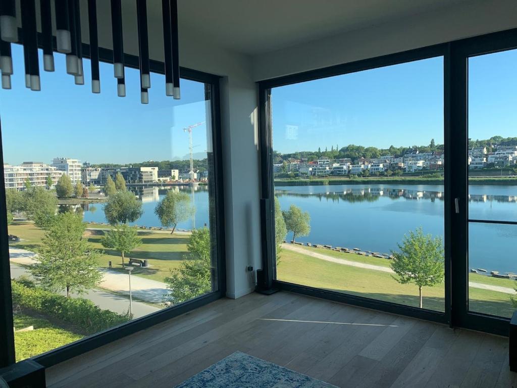 a room with large windows with a view of a lake at Traum - Apartment mit Spa im Haus in Dortmund