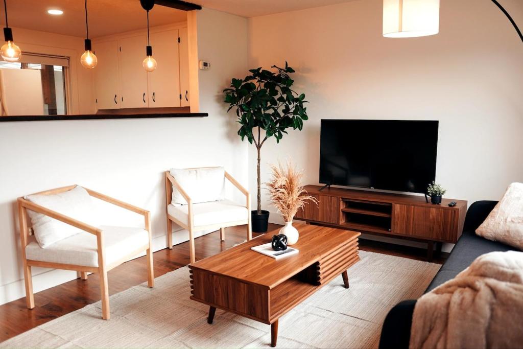 a living room with a couch and a tv at Redwood Place in Fort Saint John