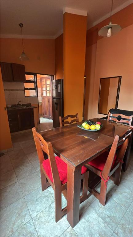 a wooden table with chairs and a bowl of fruit on it at Tu departamento en Formosa in Formosa