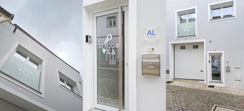 a white building with a door on the side of it at Refúgio da Vila in Vila de Rei