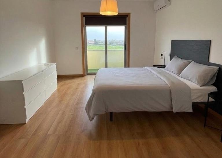 a bedroom with a large white bed and a dresser at Alojamentos Pando in Aveleda