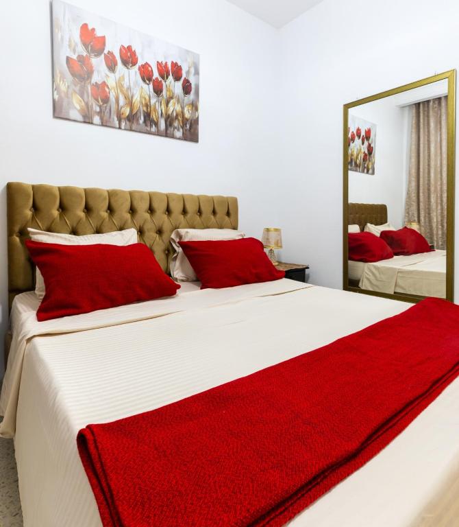 a bedroom with two beds with red pillows at VIP Home in El Aouina Station