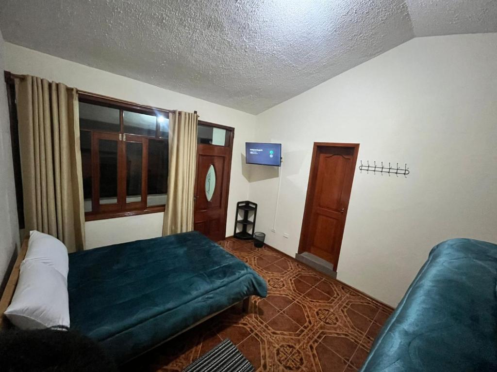 a bedroom with a bed and a window and a couch at Granja Doña Carmelita in Ibarra