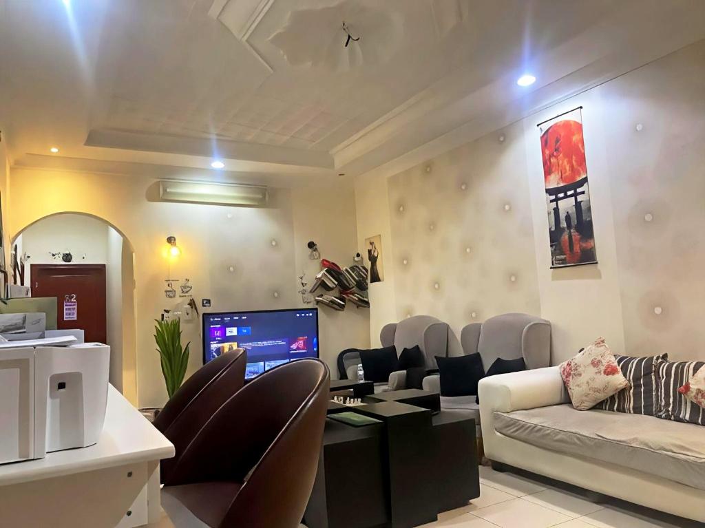a living room with a couch and a table and chairs at Your Home In Riyadh Hostel in Riyadh
