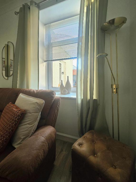 a living room with a couch and a window at The Coal House in Townhill