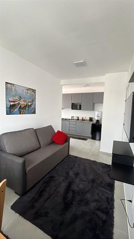 a living room with a couch and a kitchen at Doce Lar 2 in Pouso Alegre