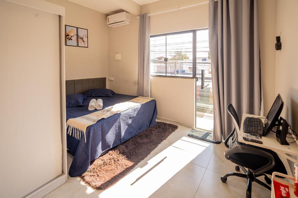 a bedroom with a bed and a desk and a mirror at Refúgio Black in Sabará
