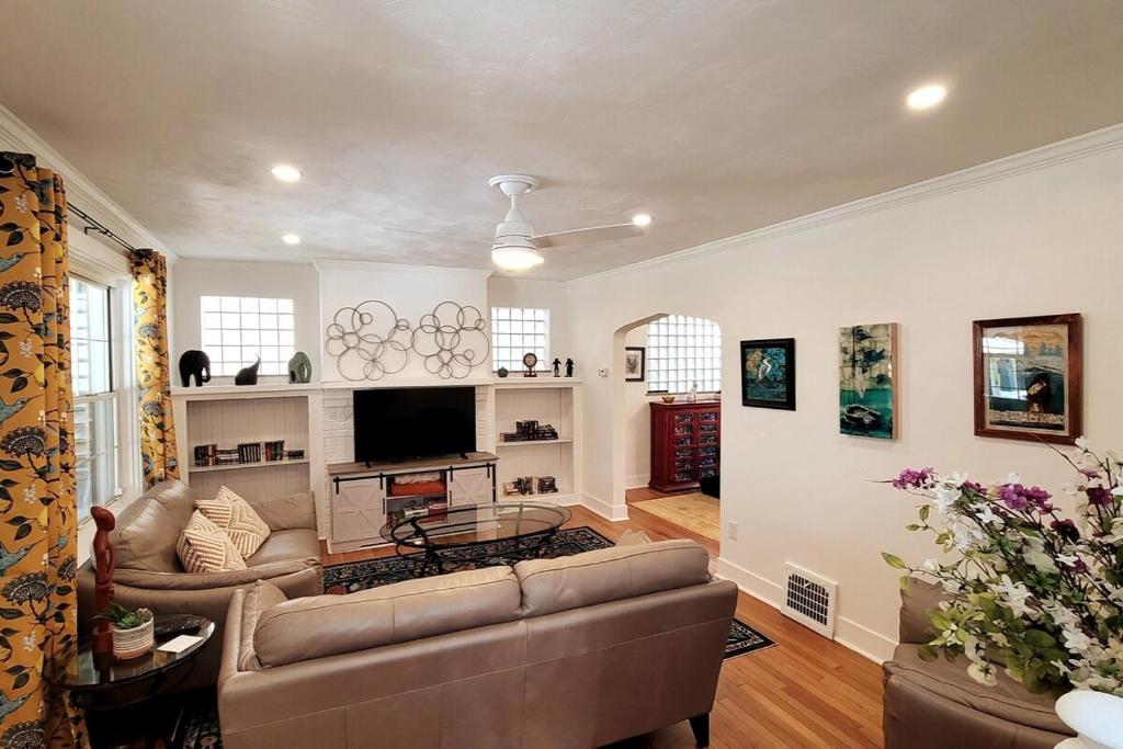 a living room with a couch and a tv at The Brookline Retreat in Pittsburgh