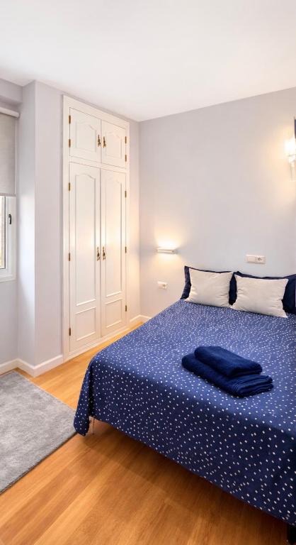 a bedroom with a blue bed with a blue blanket at Cosy and Secure Suite Marbella Center in Marbella