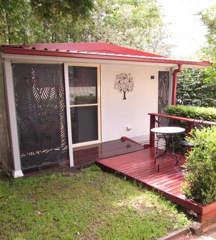 a small house with a deck and a table at Dees Rear Studio Room in Hazelbrook