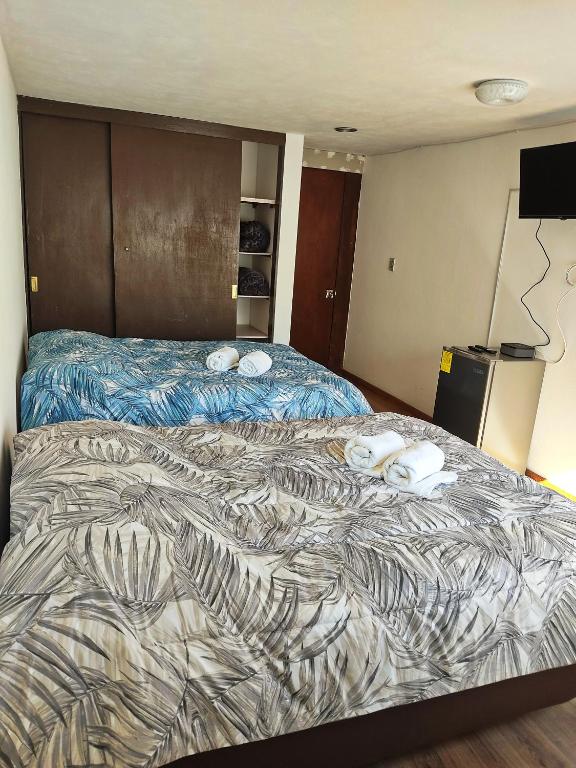 a large bed in a hotel room with two pillows on it at Suites Casa Blanca Metepec in Toluca