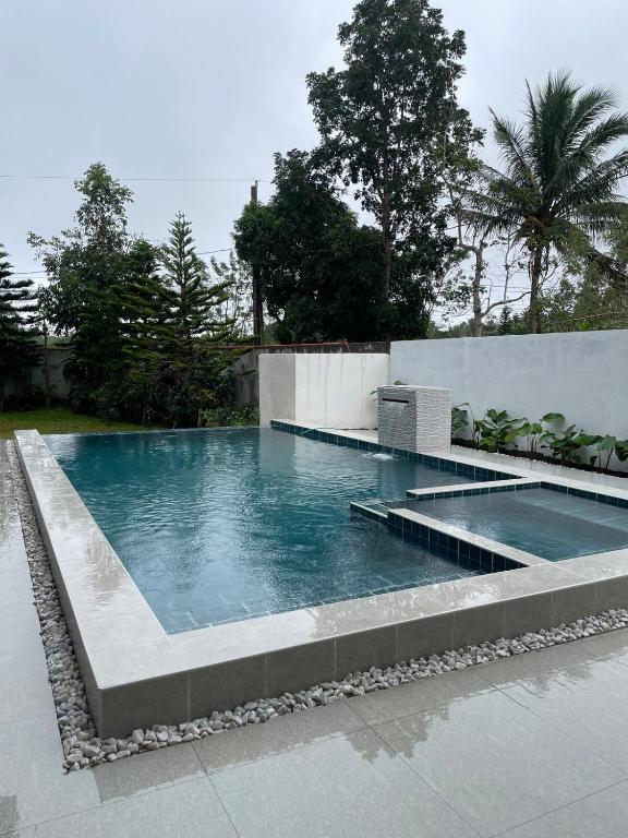 a swimming pool with blue water in a backyard at Norwil Manor Tagaytay in Tagaytay