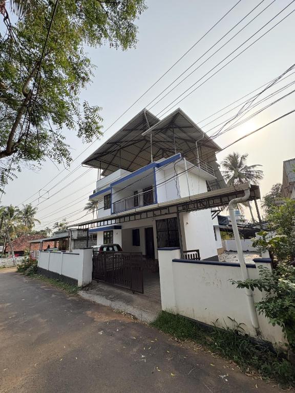 a white building with a roof on a street at Anchery homes in Trichūr
