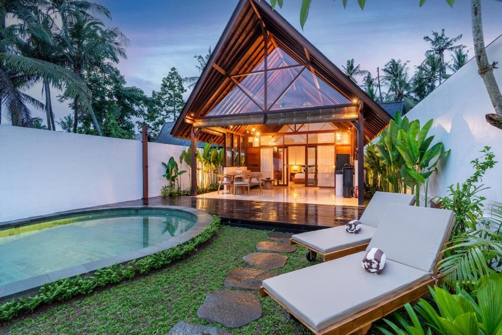 a villa with a pool and a house at Villa Apuh Rose in Ubud