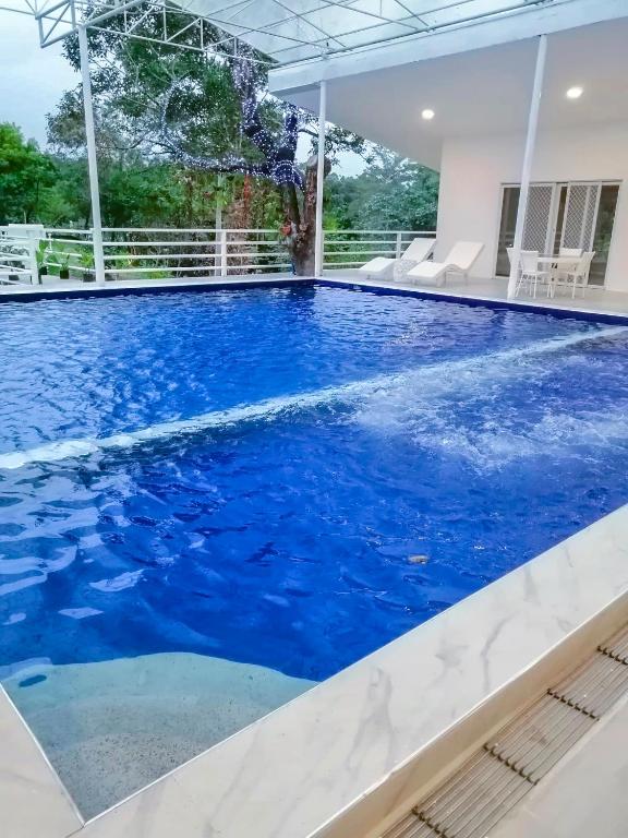 a large pool with blue water in a house at Zoobic Glampz in Subic