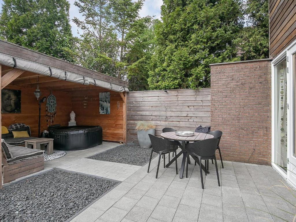 a patio with a table and chairs and a hot tub at Getaway with Bikes & Whirlpool in Grou