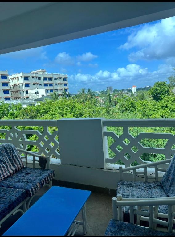 a balcony with two chairs and a blue table at Sunrise-Nyali, Mombasa in Nyali