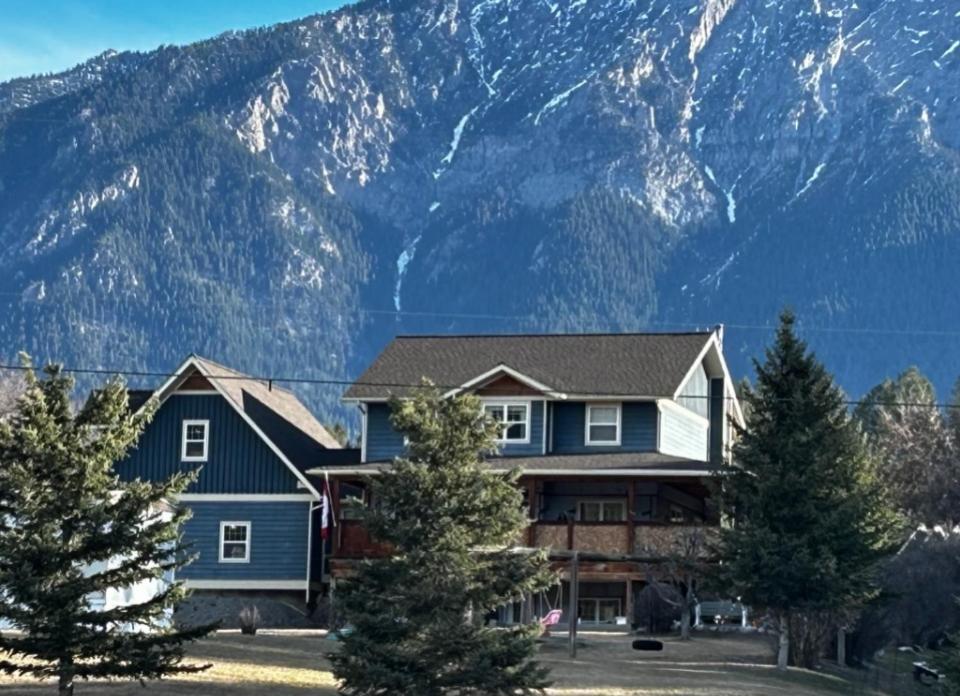 a house with a mountain in the background at Mountain Guesthouse Bed and Baking in Radium Hot Springs