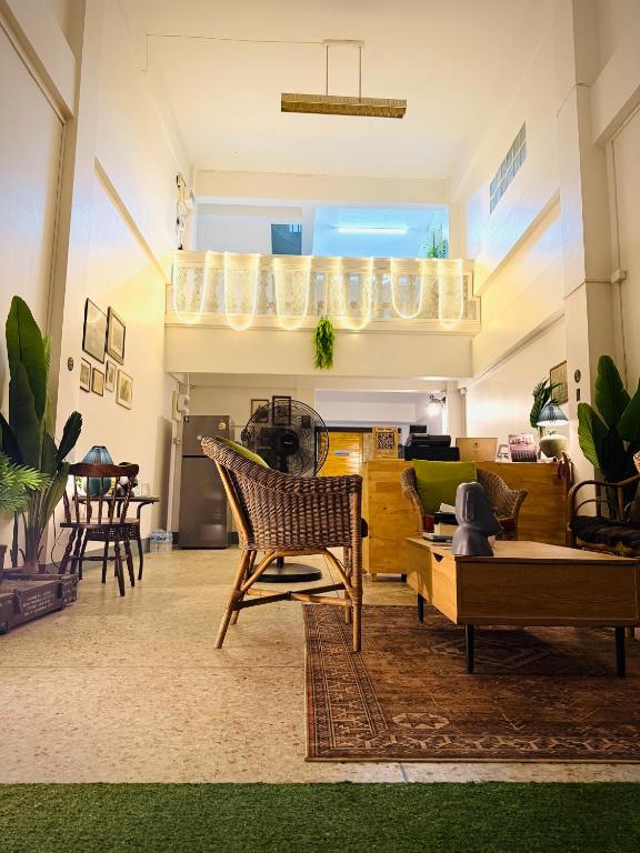 a living room with chairs and a couch at Hee Pee hostel Buriram in Sathani Buriram