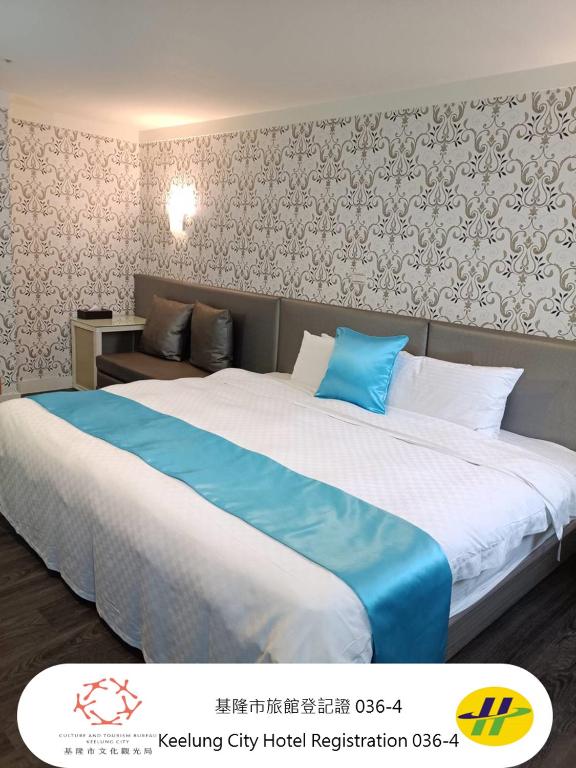 a hotel room with a large bed with blue sheets at HengChang Business Hotel in Keelung