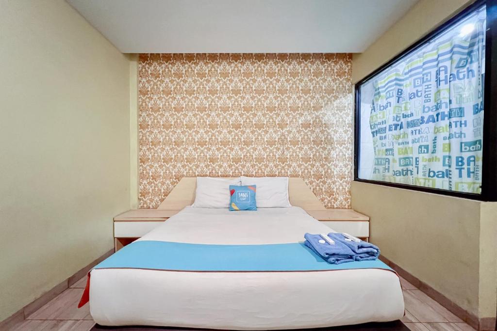 a bedroom with a bed and a projection screen at SANS Vibes Millenium Inn Medan in Pulauberayan