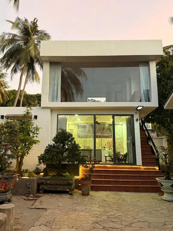 a house with glass doors and stairs in front at Peaceful Hilltop Duplex Central Phu Quoc in Phú Quốc