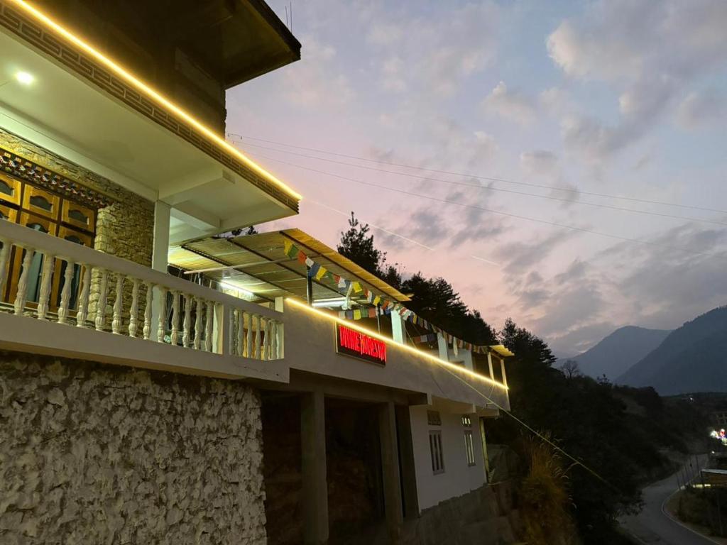 a building with a balcony with a view of a mountain at Divine Homestay Dirang in Dirang Dzong