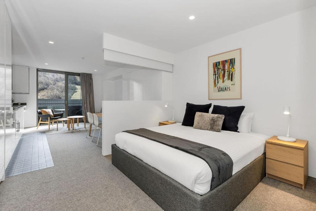 a bedroom with a large bed and a dining room at Squatters Run 26 in Thredbo