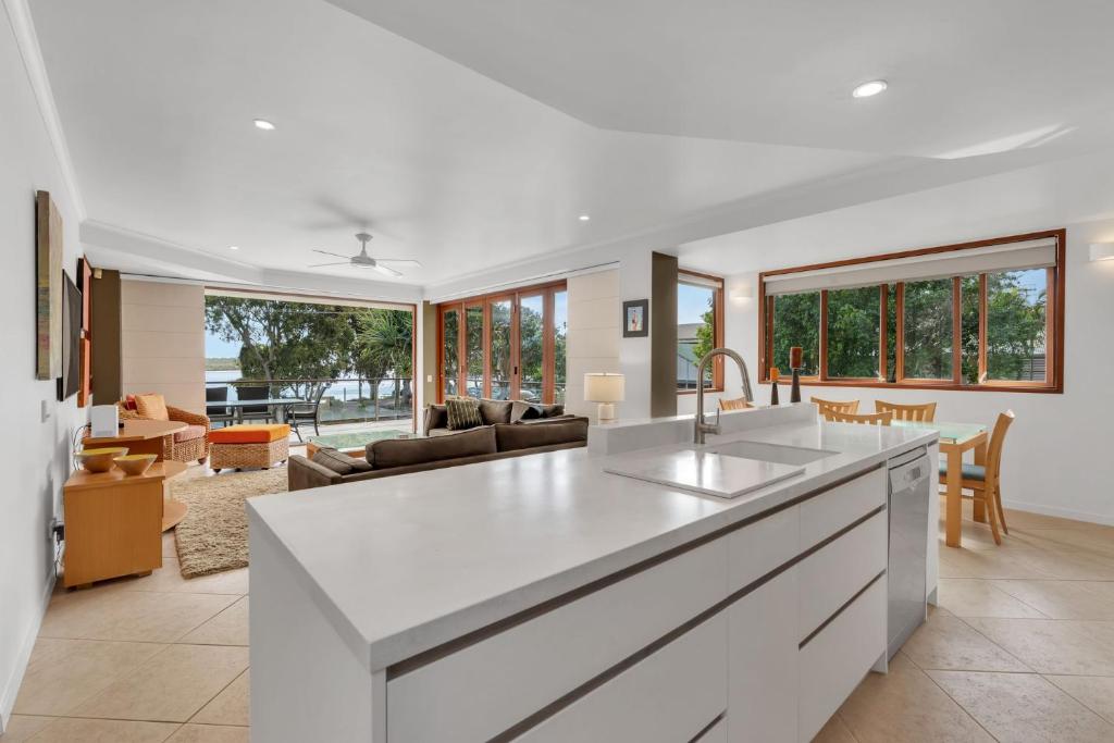 a kitchen and living room with a white counter top at Nouvelle in Noosaville
