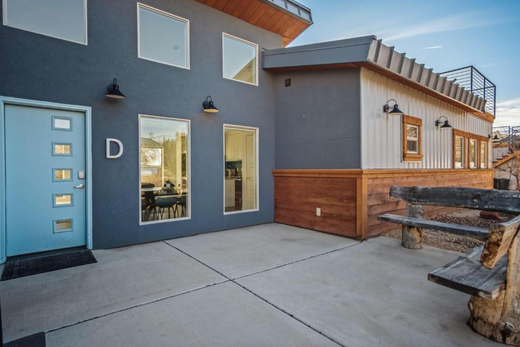 a house with a blue door and a bench at Timber & Tin D 2Bed 2Bath w Pool & Rooftop Deck in Kanab