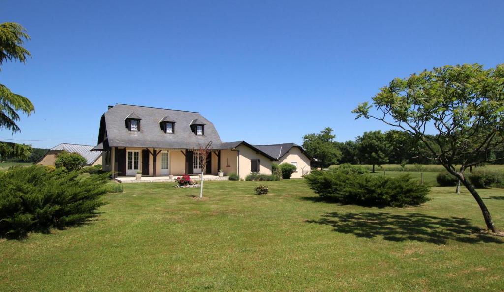 a house with a gambrel roof on a lawn at Sarthou in Espéchède