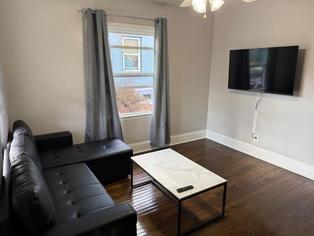 a living room with a leather couch and a coffee table at Cozy 1 Bedroom Bungalow in Charlotte