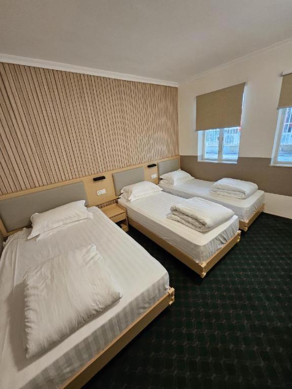 a room with three beds in a room at Man Va Hotel in Macau