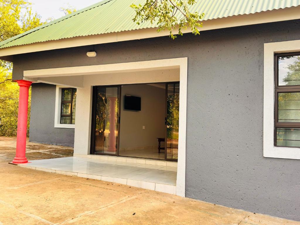 a gray house with a large glass door at Unogwaja Rest in Marloth Park