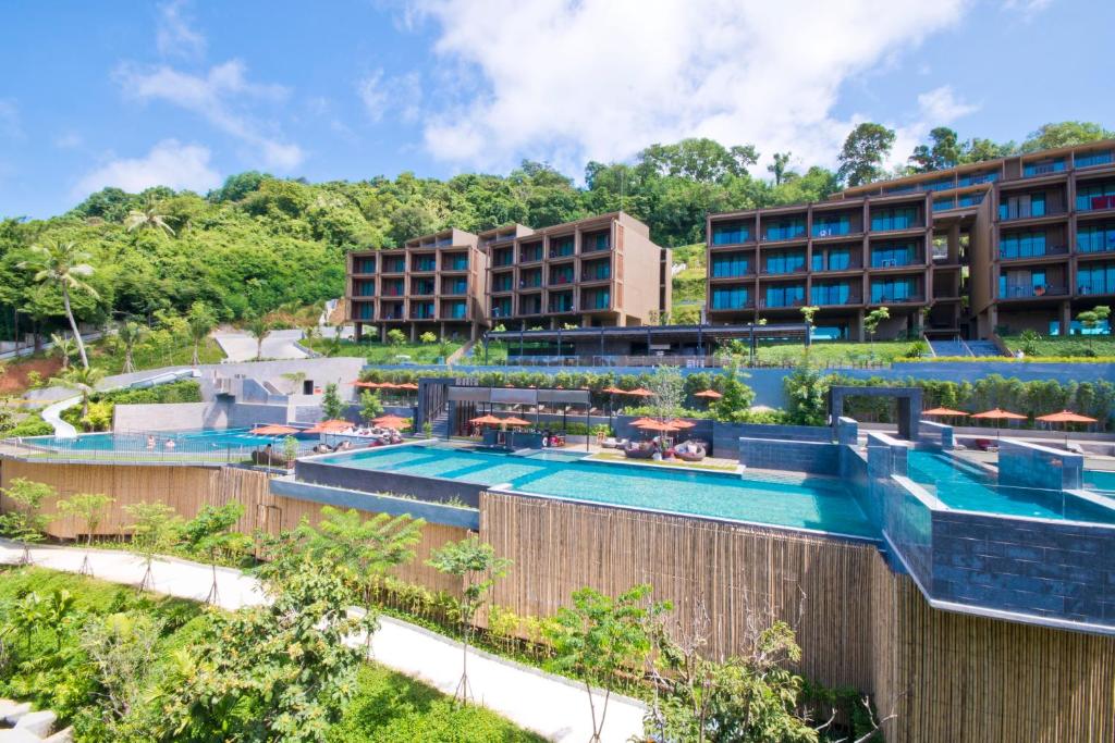 a resort with a swimming pool and some buildings at Sunsuri Phuket - SHA Plus in Nai Harn Beach