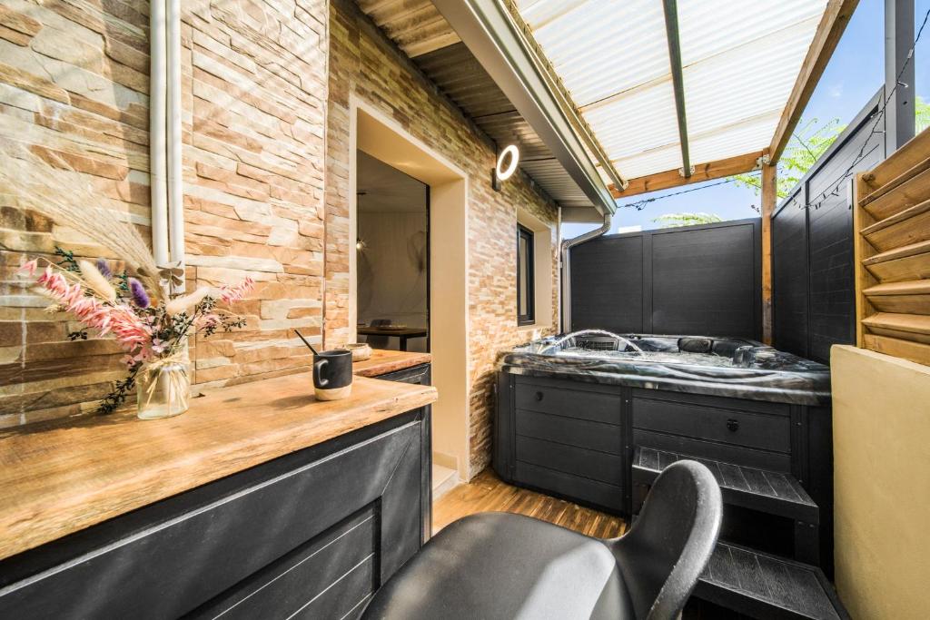 a kitchen with a sink and a counter with a chair at La Fabrik' - Studio avec jacuzzi privé à La Réunion in Le Tampon
