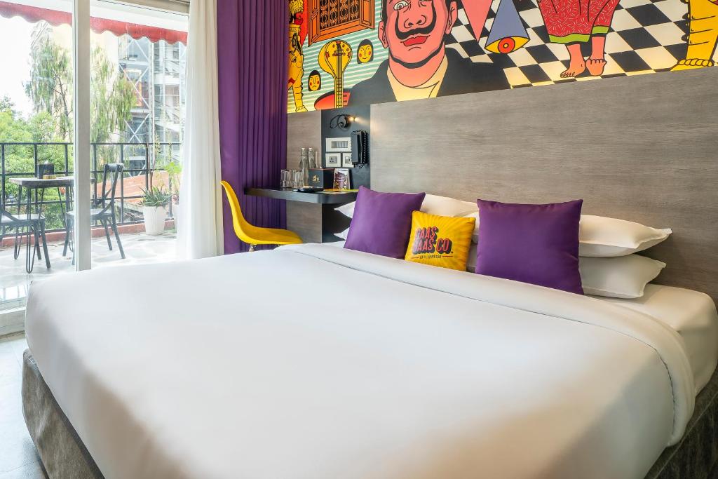a bedroom with a large white bed with purple pillows at GaasBaasCompany, Thamel, Kathmandu in Kathmandu