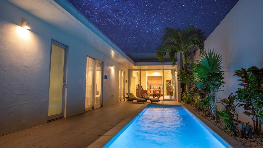 a swimming pool in a house with a star ceiling at Feliz Villa Suite Miyakojima Ueno in Miyako-jima