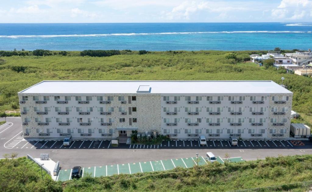 an aerial view of a building with the ocean in the background at コート エトワレ マエザト-新築アパートメントホテル- in Ishigaki Island
