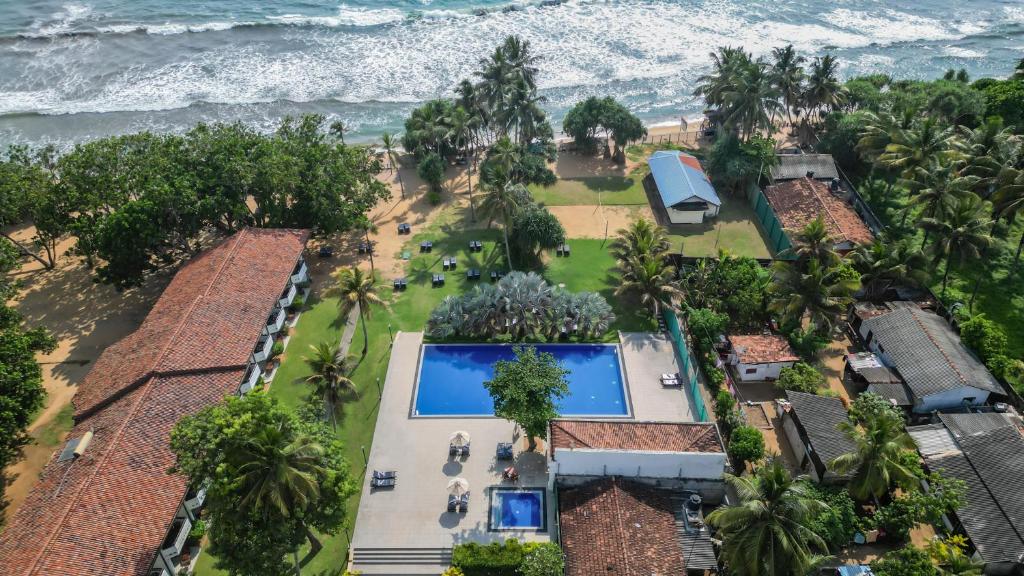 an aerial view of a resort with a swimming pool and the ocean at Hibiscus Beach Hotel & Villas in Kalutara
