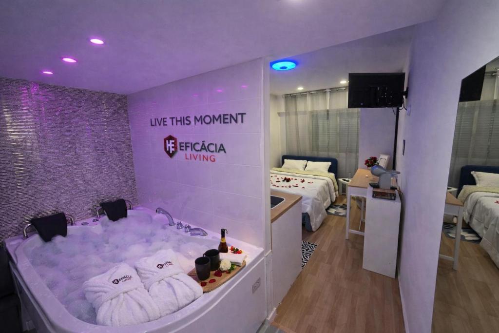 a room with two beds and a tub with towels at Spa & Jacuzzi Dupla Privada Escapadinha Romântica Abrantes in Abrantes