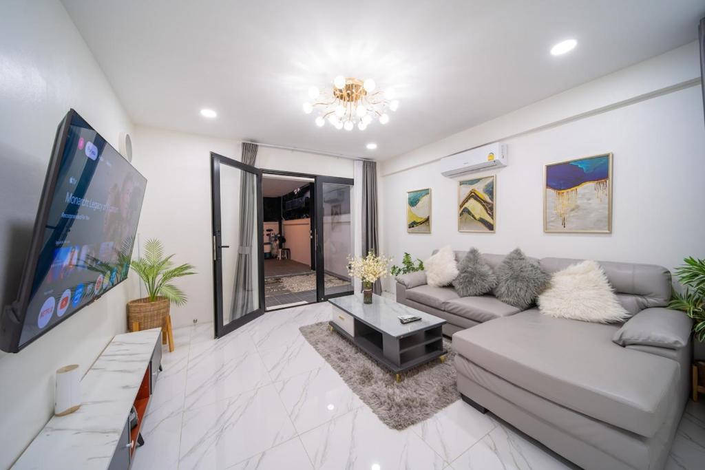 a living room with a couch and a flat screen tv at Mango Breeze Villa in Ban Nong Chaeng