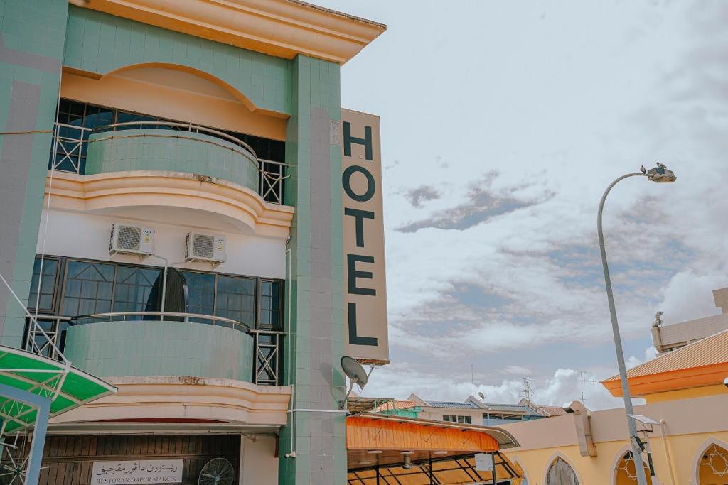 a hotel sign on the side of a building at Hotel Koperasi in Seria