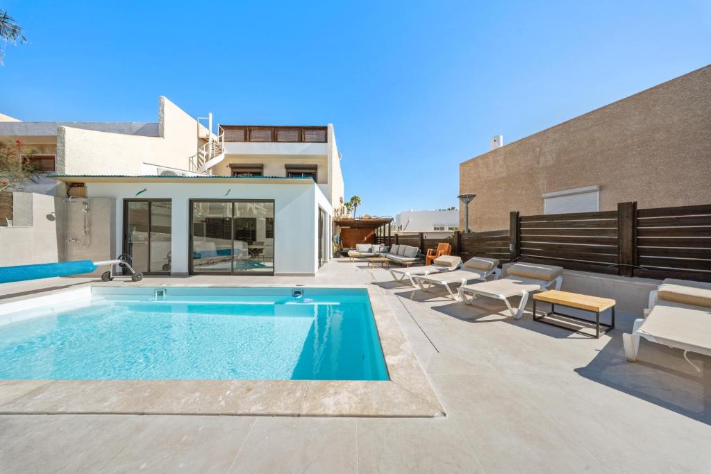 a swimming pool on a patio next to a house at Villa Ella in Eilat