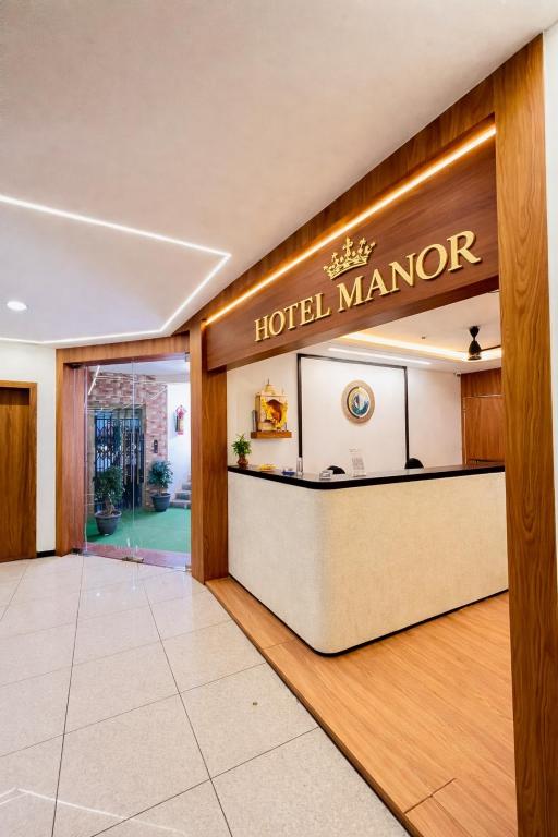 a hotel manor lobby with a hotel manager sign on the wall at Hotel Royal Manor in Rajkot