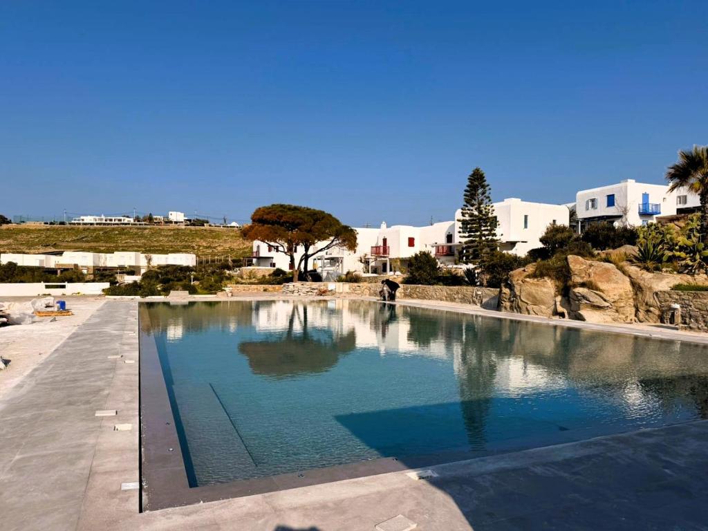 a large pool of water with buildings in the background at Bluewave Lux house in Ornos