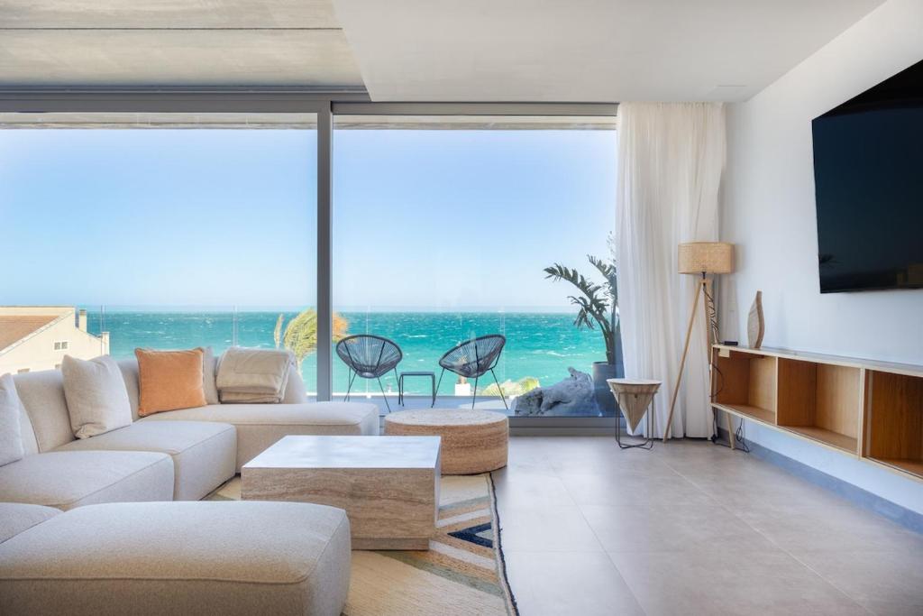 a living room with a view of the ocean at Luxury Villa Lumina with Arcade & Pool Table, PS5 in Can Picafort