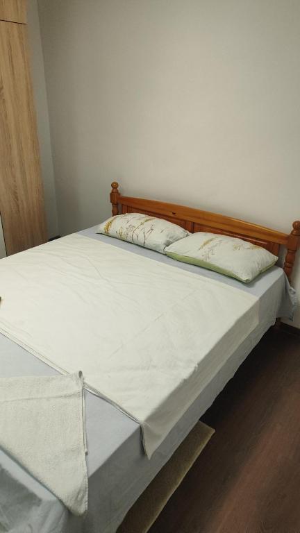 a bed with two pillows on top of it at Апартамент Луиза in Varna City