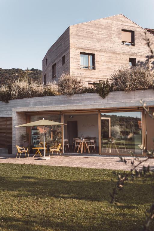 a building with tables and chairs in front of it at Ca' San Matteo in Tesserete