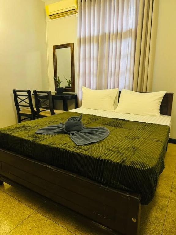 a bed in a bedroom with a mirror and a window at Villa i in Dehiwala